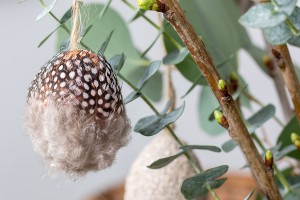 Osterei mit Federn beklebt