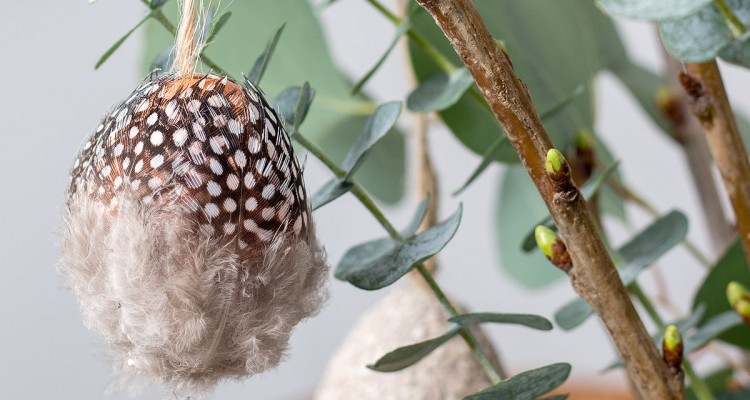 Osterei mit Federn beklebt