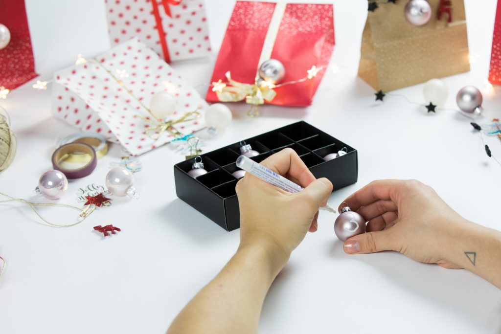 Mit einem Textmarker beschriftet ihr die Weihnachtskugeln.