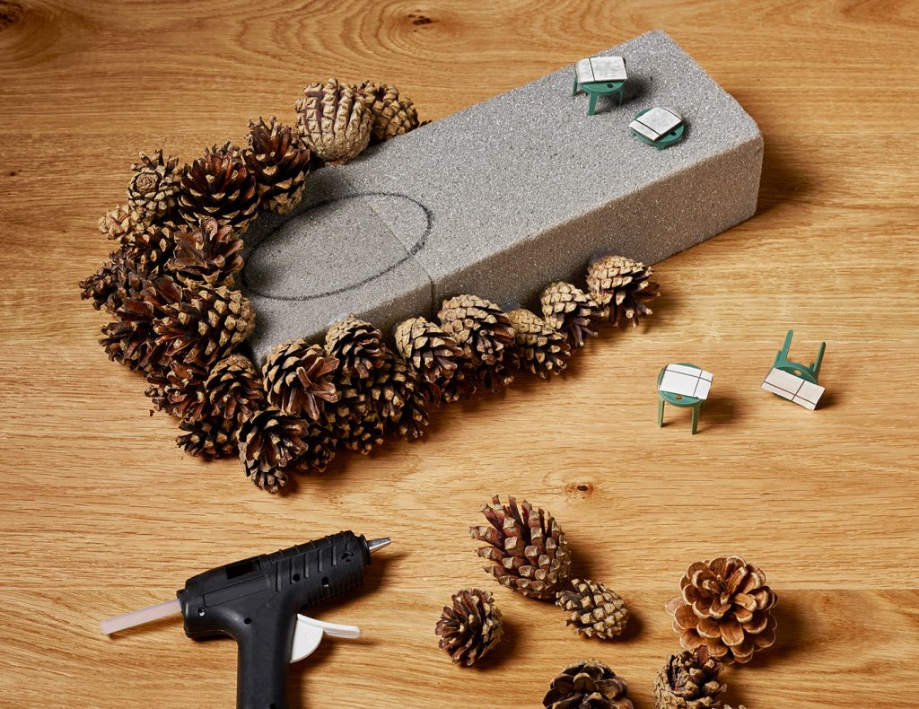 Mit der Heißklebepistole befestigt ihr die Zapfen am Steckschaum.