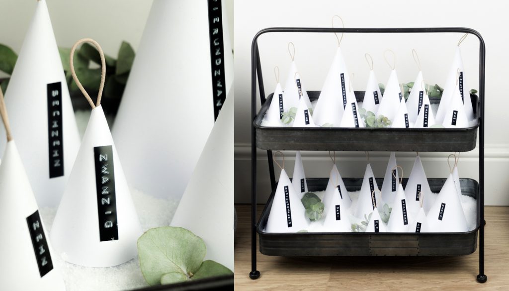Zuletzt versteckt ihr für den Adventskalender verschiedene Süßigkeiten unter den Kegeln und platziert diese auf einer Unterlage - ich habe eine Etagere mit Dekoschnee gewählt.