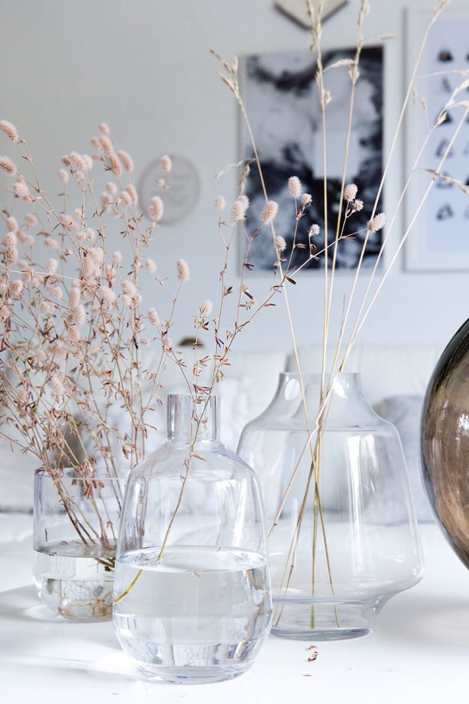 schlichte-filigrane-glasvasen-mit-graesern-als-wohnzimmerdeko
