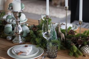 Weihnachtstischdeko mit Tanne, Moos, Zapfen und Weihnachtskugeln