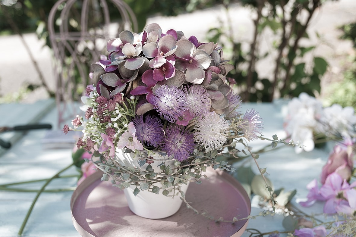 Dekokäfig mit Kunstblumen schmücken