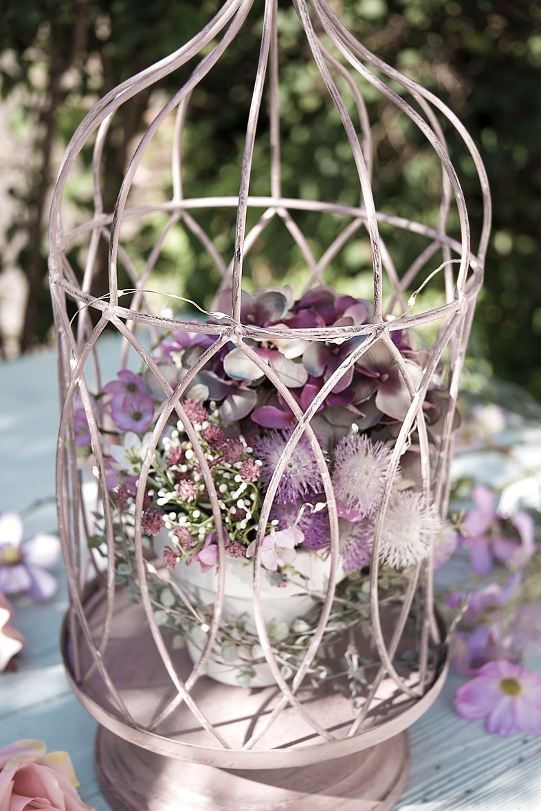 Dekokäfig mit Lichterkette und Kunstblumen schmücken