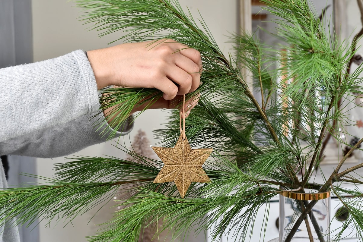 Kiefernzweige mit Sternen schmücken.