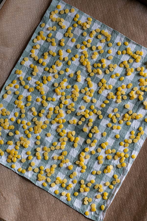 1. Schritt: Stoff in beliebiger Größe zurechtschneiden, auf ein mit Backpapier ausgelegtes Blech legen, mit Olivenöl bepinseln und Bienenwachs Pastillen verteilen