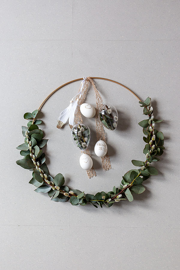 Anhänger-Eier in verschiedenen Höhen anbringen und oben am Metallring 2 Federn befestigen