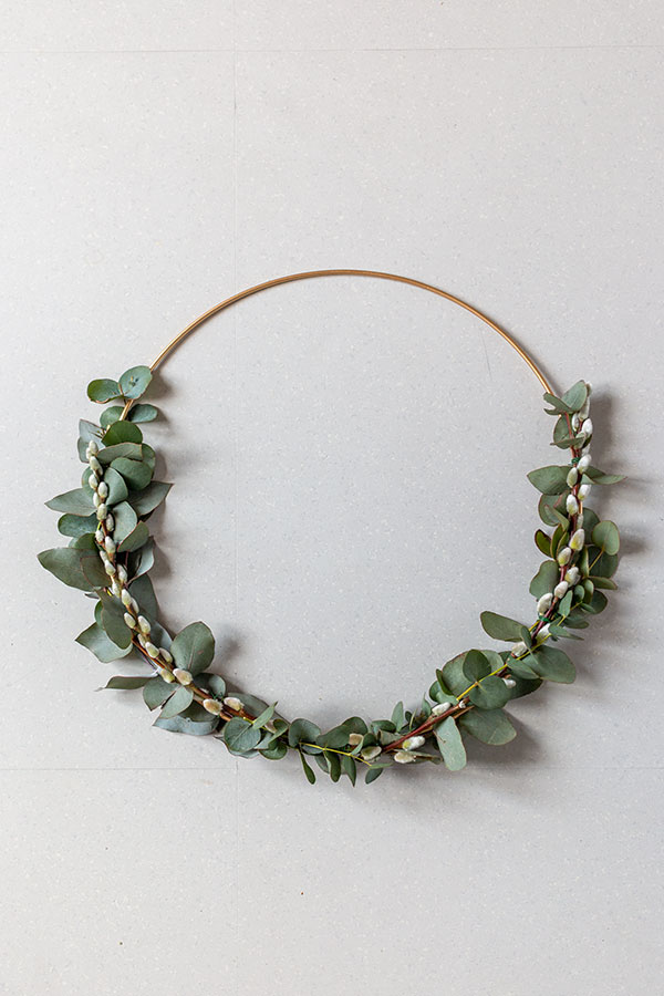 Weidenkätzchen auf den Eukalyptus legen und mithilfe von Floristendraht am Metallring befestigen