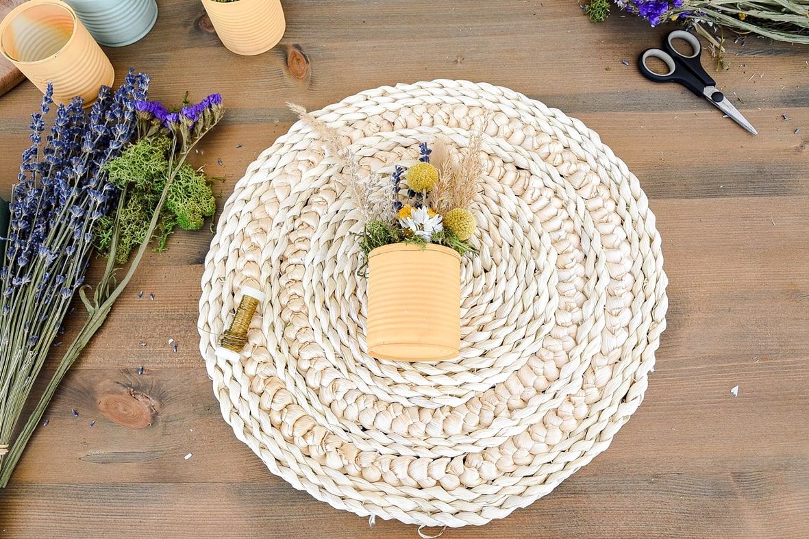 Dosen mit Basteldraht auf Tischsets befestigen.